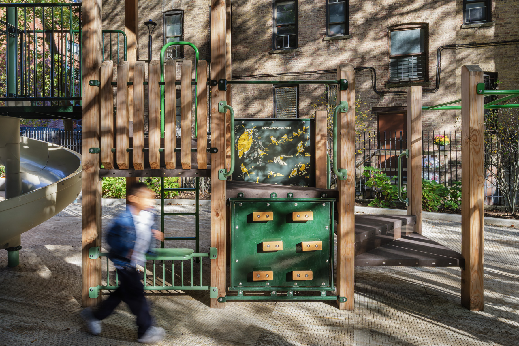 NYCHA PACT Audubon Houses playground featuring bird education panel and natural wood play structure in Washington Heights Manhattan