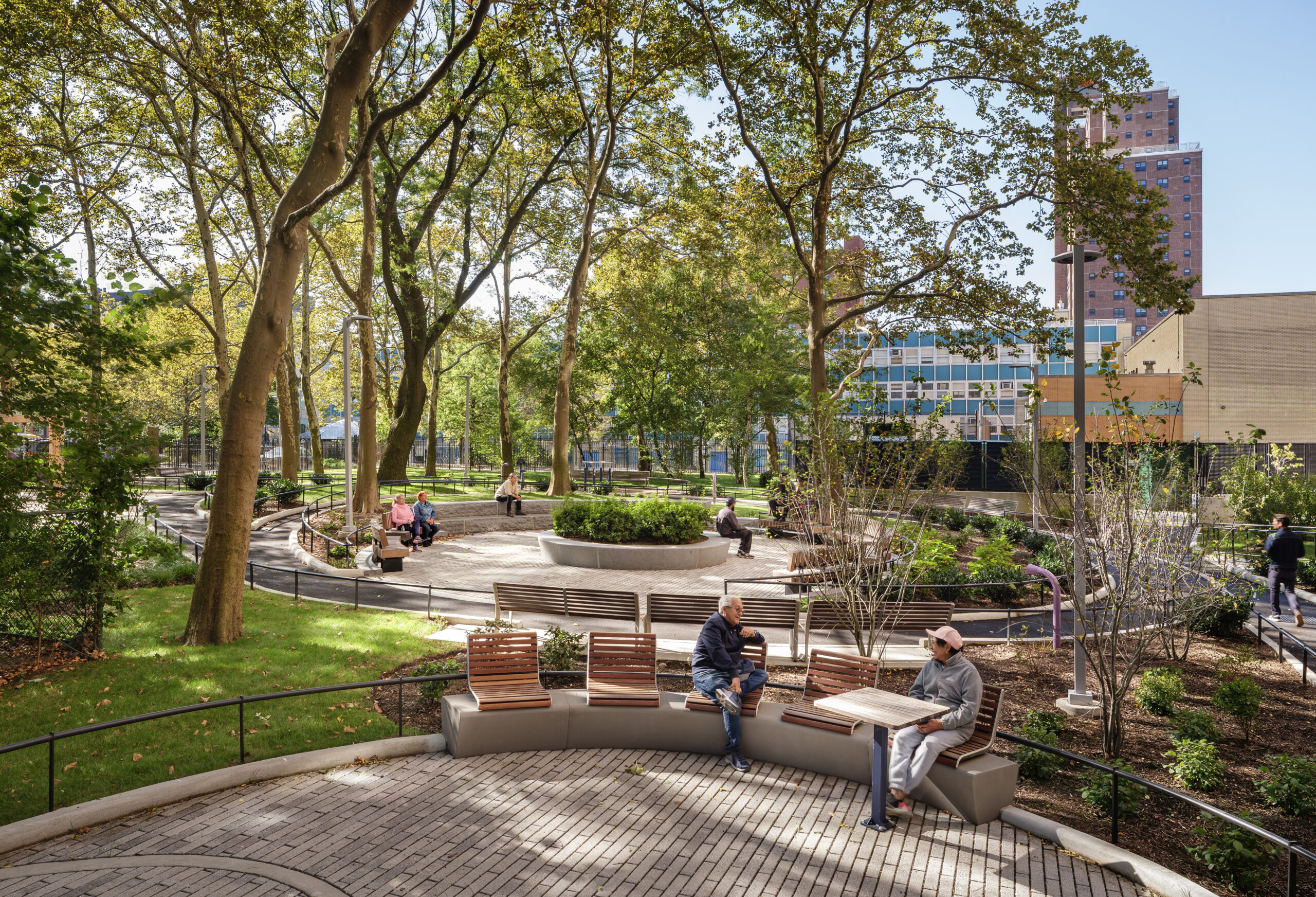 Bethune Gardens – Curved Seatwall Detail Residents seated along curved concrete and wood seatwalls at Bethune Gardens NYCHA landscape renovation in Washington Heights